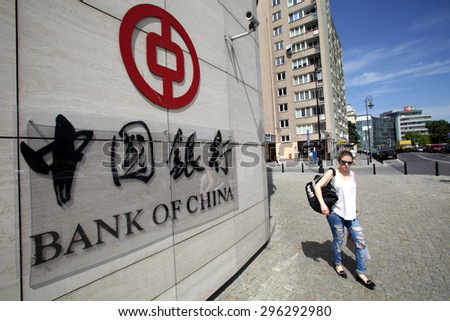 WARSAW, POLAND - SATURDAY, JUNE 6, 2015: A pedestrian walks past the offices of the Bank of China in Warsaw. Bank of China Limited is one of the 5 biggest state-owned commercial banks in China.