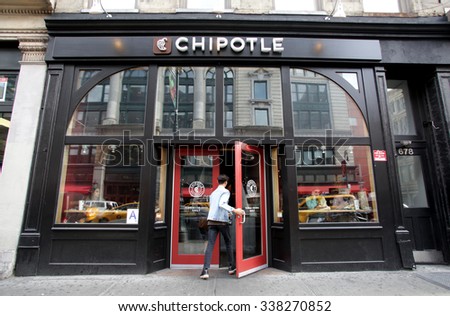 NEW YORK CITY - OCTOBER 22, 2015: Pedestrians walk past a Chipotle Mexican fast food restaurant. Chipotle Mexican Grill, Inc. is a chain of restaurants.