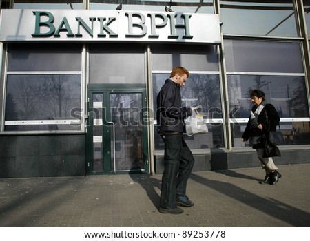 KRAKOW, POLAND-MARCH 15: Unidentified people walk past an office of Bank BPH on March 15, 2004 in Krakow, Poland. Bank BPH Banku is a Polish bank that is 66 percent owned by GE Money Bank.