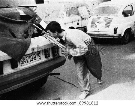 SARAJEVO, BOSNIA - MAY 23: A young boy runs behind a car while playing war with friends using a homemade gun in Sarajevo, Bosnia, on Sunday, May 23, 1993. The Bosnian capital has been under siege for more than one year.