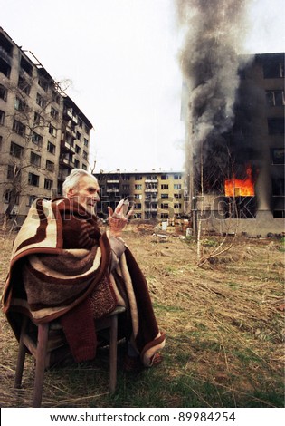 SARAJEVO, BOSNIA - MAR 18: An ethnic Croatian man prays outside his burning apartment on the last day of the Serbian siege in Sarajevo, Bosnia, on Monday, March 18, 1996.