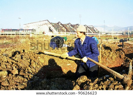 SARAJEVO, BOSNIA - JAN 15: Workers dig fresh graves in the shadow of the 1984 Winter Olympic stadium at the Lion cemetery in Sarajevo, Bosnia, on Monday, January 15, 1993.