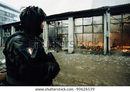 SARAJEVO, BOSINA - MARCH 18: Italian army troops, in Bosnia as part of the United Nations' UNPROFOR, patrol a burning outdoor market on March 18, 1996 in Sarajevo, Bosnia.