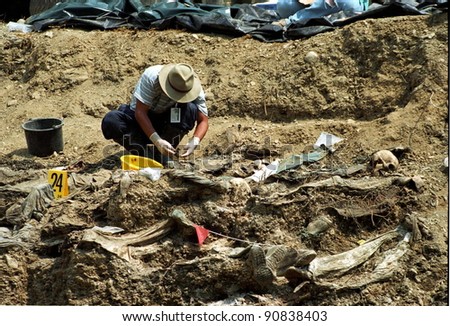 SREBRENICA, BOSNIA - JUNE 12: United Nations forensic experts unearth victims from a mass grave. The victims are among the estimated 8000 civilians killed by Bosnian Serb soldiers in July 1995 on June 12, 1996 in Srebencia, Bosnia.