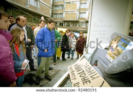 BELGRADE, YUGOSLAVIA - MARCH 30: Belgrade citizens stare through the smashed windows of the American Cultural Center, destroyed by rampaging mobs of angry Serbs protesting NATO airstrikes on March 30, 1999 in Belgrade, Yugoslavia