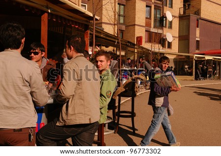 PRISTINA, KOSOVO - JAN 26: A young boy sells cigarettes to crowds of mostly out-of-work young men at a cafe in Pristina, Kosovo, on Saturday, January, 26, 2008.