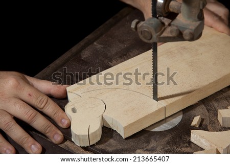 A craftsman cutting a wood head horse with bandsaw