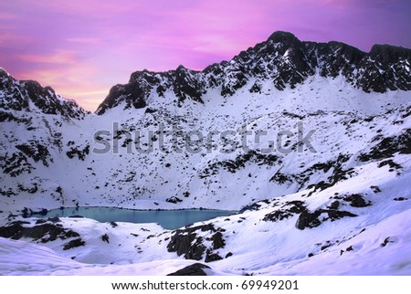 Glacier lake and the Alps mountains covered by snow at sunrise.