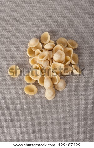 Pile of Pasta orecchiette on a beige table cloth