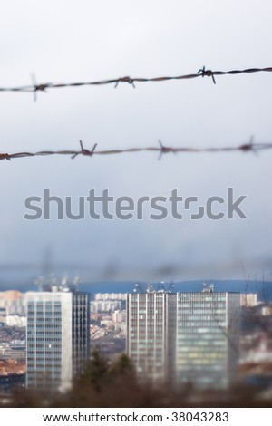 tilt-shift photo, barbed wire over panel buildings, Brno, Czech Republic. illustration of cummunism in former Czechoslovakia.