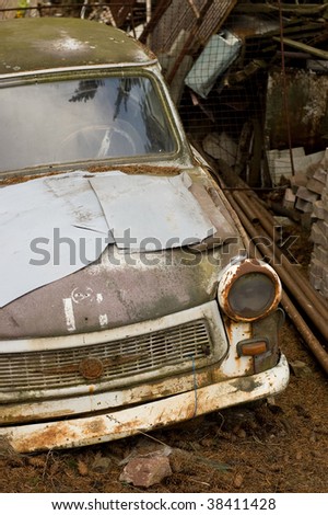 wrecked vintage german plastic car in dirty yard