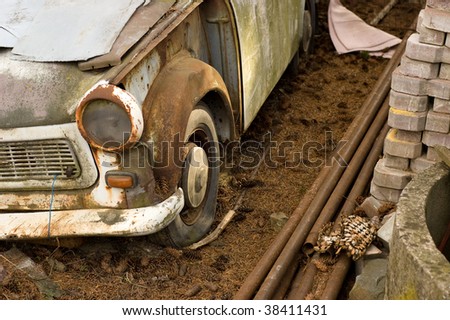 wrecked vintage german plastic car in dirty yard
