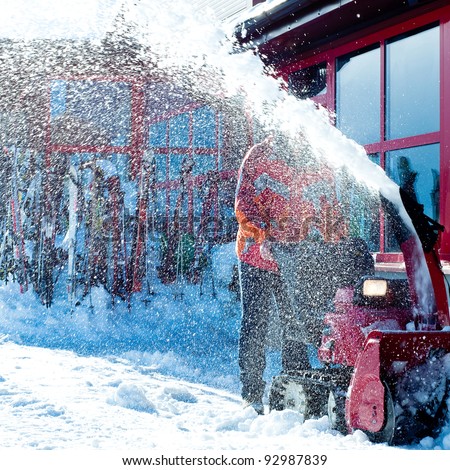 man using powerful snow blower to remove heavy snow from his front yard