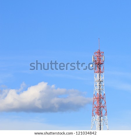 Red and white roof top cellular tower under blue sky