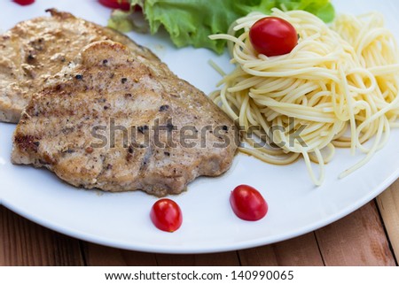 Eating pork steak with spaghetti