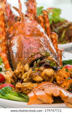 a luxury dish of lobster roasted and decorated with many items of vegetable
