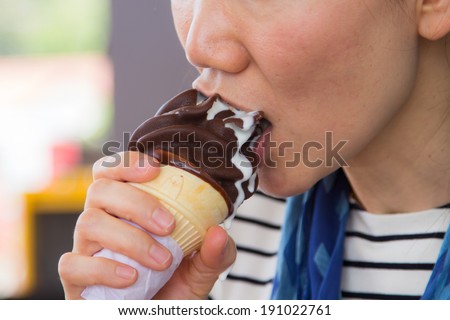 Asian girl eating ice cream happily.