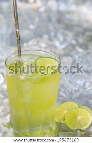 Lemon juice glass and fresh lemons. Isolated on ice background