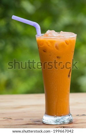 Thai Ice Tea milk isolate on green background