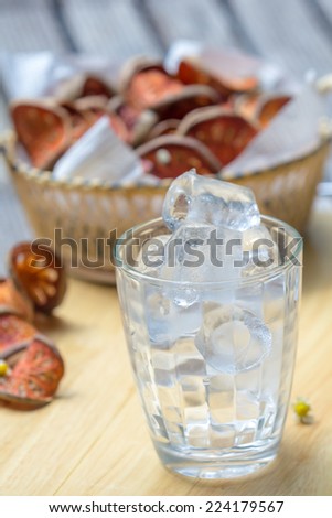 close up ice in glass on wooden cutting board
