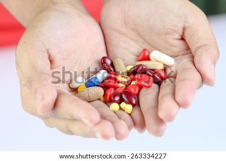 Many pills in hand on white background