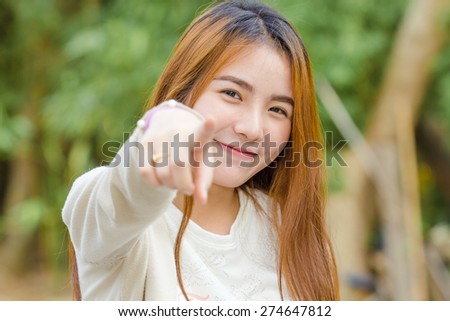 young woman point finger at you looking at camera