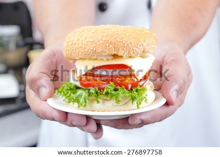 chef holding american cheese burger with fresh salad