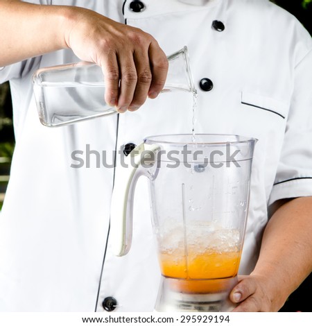 chef making smoothies orange juice in Blenders
