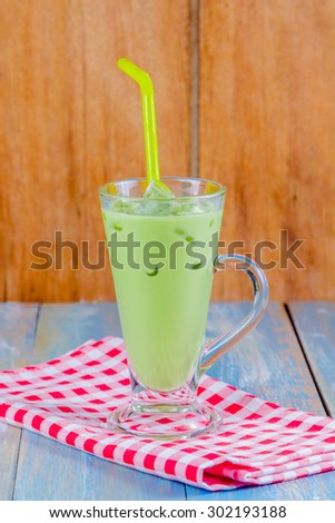 Iced green tea with milk on wooden