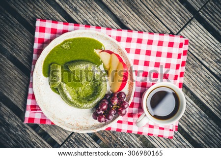 Green tea cake with fruit in plate on wooden