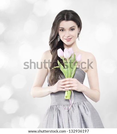 Beautiful young brunette woman with tulip bouquet. Elegant portrait