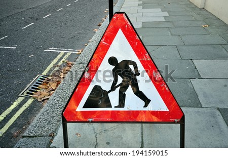 triangular construction sign standing on footpath fto remind construction area ahead