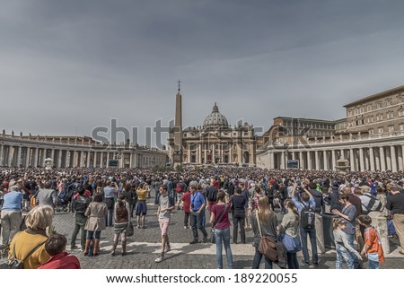 ROME - APRIL 13 2014: A group of believers, in St. Peter\'s Square on Palm Sunday during the Eucharistic blessing of Pope Francis. Pope Francis on the big screen. April 13, 2014, Vatican City, Italy