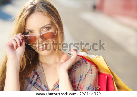 Shopping Girl in front of shopping center holding shopping bags