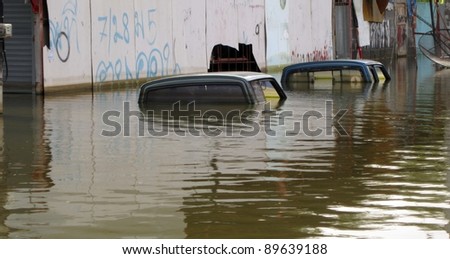 LAMLUKKA (PATHUMTHANI), THAILAND – CIRCA NOVEMBER 2011 – Two flooded cars in the floodwater circa November 2011 in Lamlukka. The entire province has been flooded due to an unprecedented rainy season.
