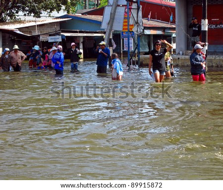 LAMLUKKA (PATHUMTHANI), THAILAND – CIRCA NOVEMBER 2011 A group of unidentified people eats and talks in a flooded road circa November 2011 in Lamlukka.