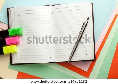 Open note book with lined pages free date space and ballpoint pen and markers.