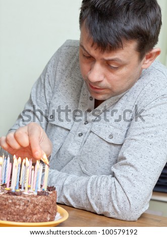 Adult celebrates his birthday. Man lighting the candles