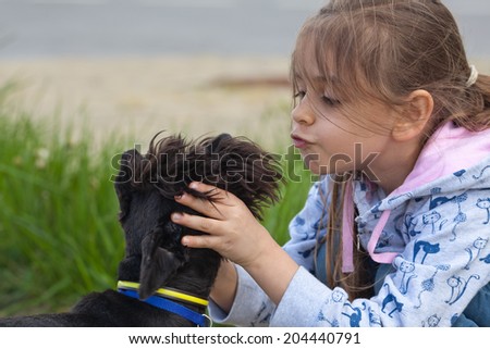 Little girl kissing her pet dog