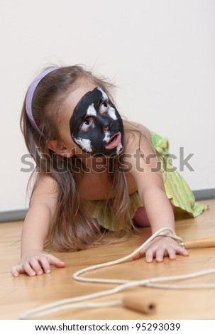 Little girl playing role game: Dog on a walk. Black and white colors is on little girl\'s face