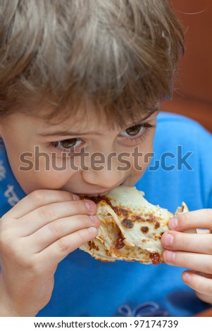 Young boy eats pancake with jam