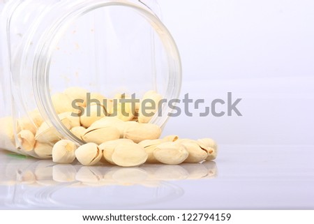 pistachios salt spilling out over a white background