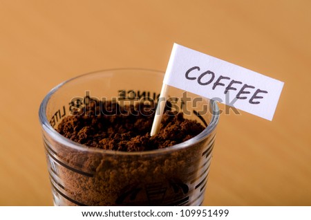 A Shot Glass of Coffee Grounds with name tag