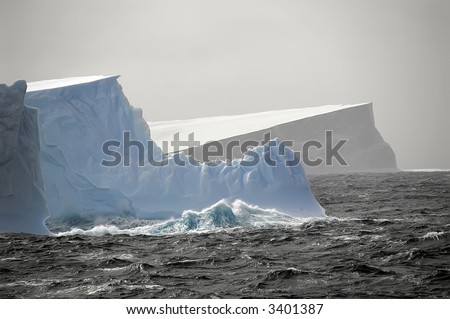 Three Antarctic icebergs in the stormy sea close to the peninsula. Picture was taken during a 3-month research expedition to the formerly inaccessible Larsen area.