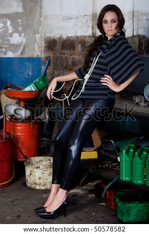 A young brazilian female model shot in a dirty auto repair shop.