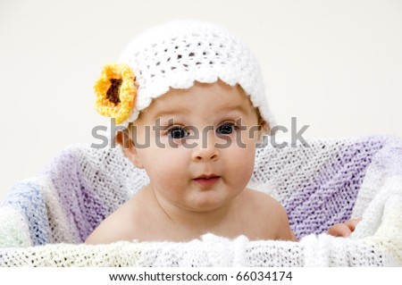 Portrait of Baby Girl in Crochet Hat with Expressive Face.
