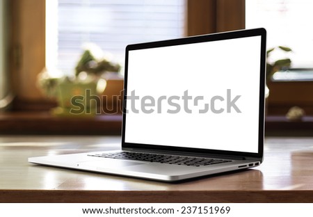 Notebook with blank screen on table in living room.