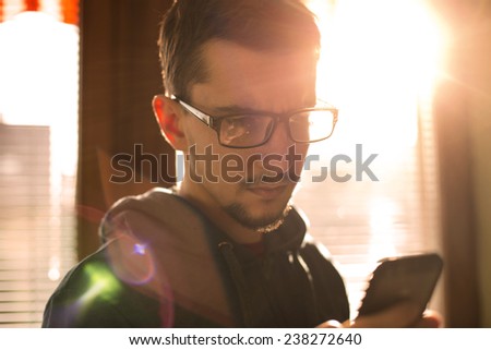 Man in glasses using smartphone.