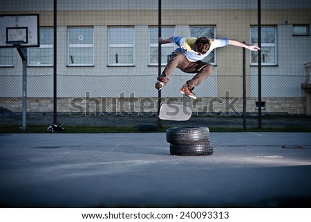 Skater doing the back side flip trick over the tyres.