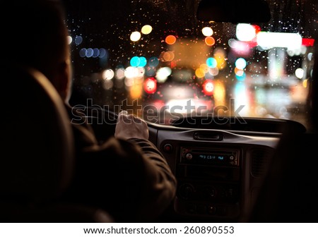 Driving in night scenery, hands on steering wheel.